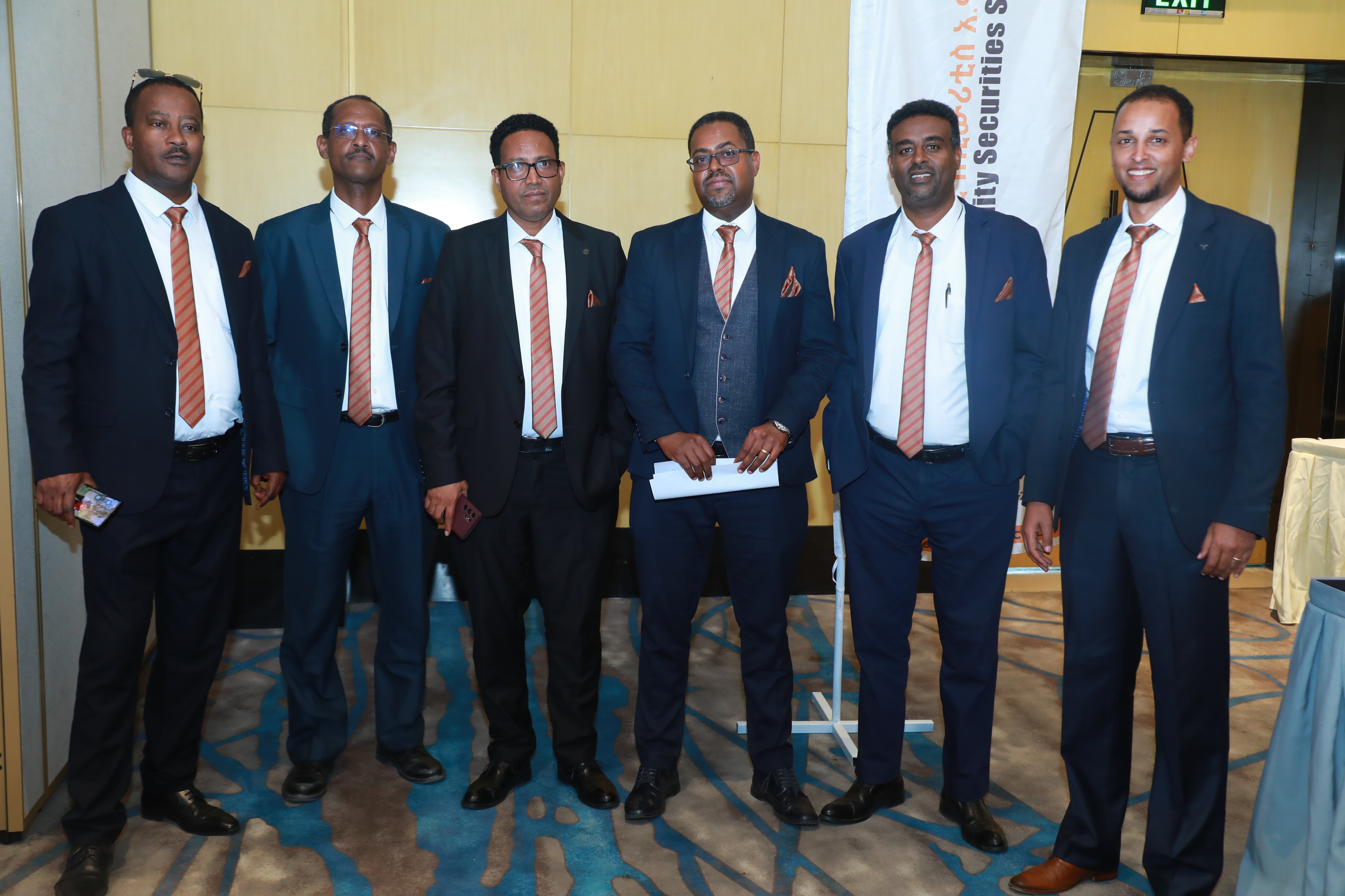 Six Ethio Fidelity directors in matching orange ties at a company event in Addis Ababa
